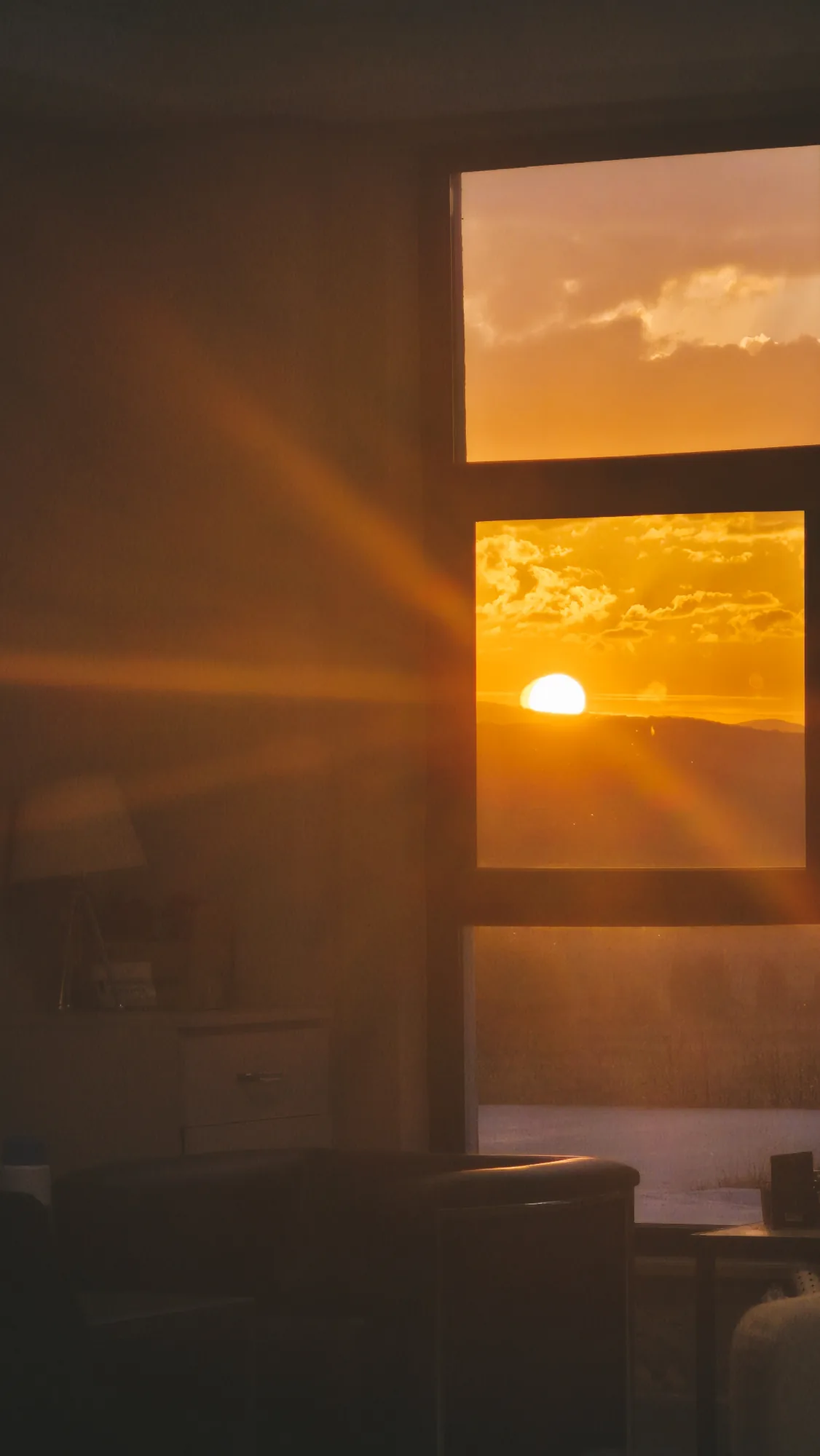Sunset light pouring through a window into a dim room