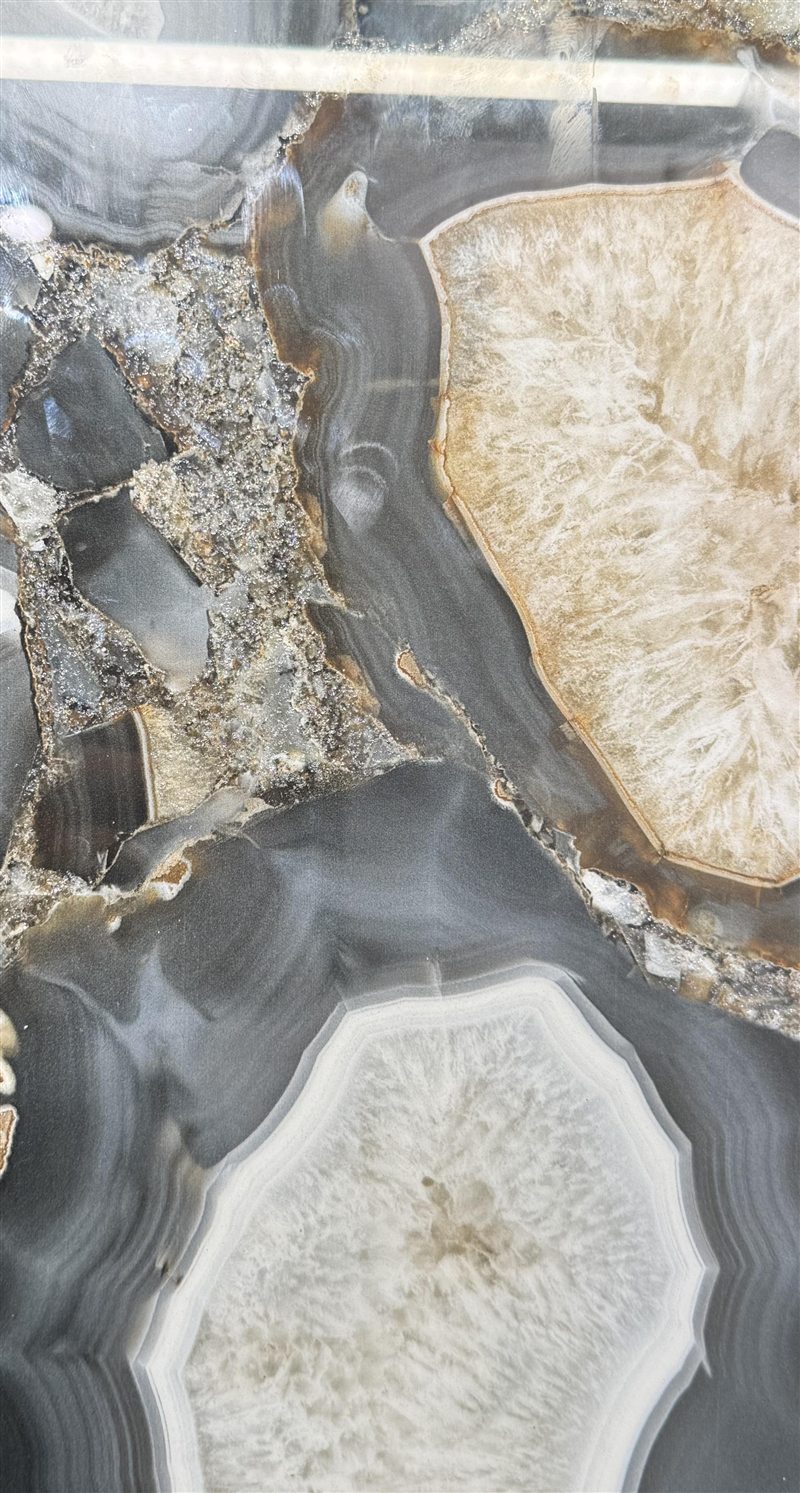 Close-up of a polished agate-look surface in grey, cream and amber